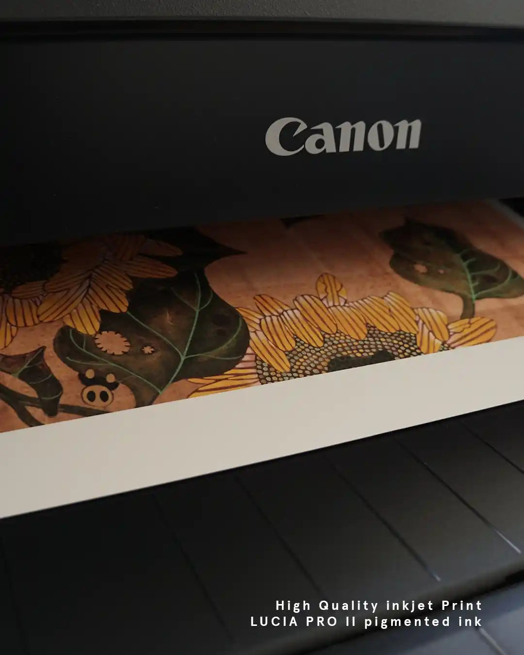 A close-up photograph showing a fine art print emerging from a Canon printer. The detailed artwork features warm yellow sunflowers with intricate line patterns and dark green leaves against a textured brown background, with white text overlay at the bottom right reading "High Quality inkjet Print LUCIA PRO II pigmented ink."