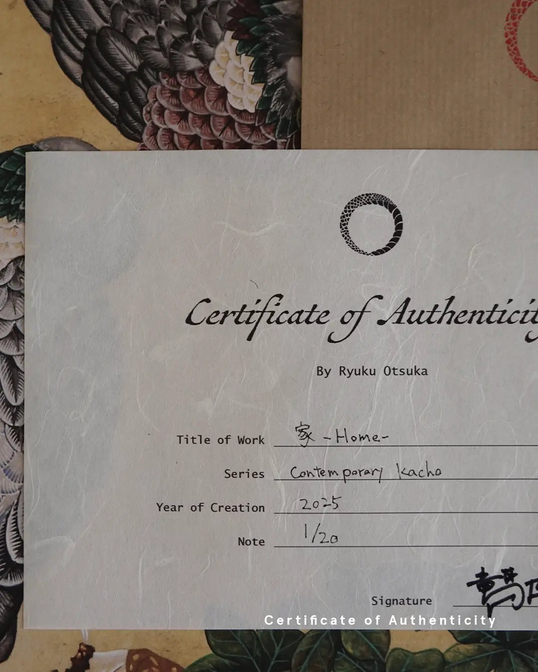 A close-up photograph of a handwritten Certificate of Authenticity printed on textured white washi paper for the artwork "家 - Home -" by Ryuku Otsuka. The document details the series "Contemporary kacho," creation year 2025, limited edition numbering "1/20," and the artist's signature in Japanese kanji at the bottom right.