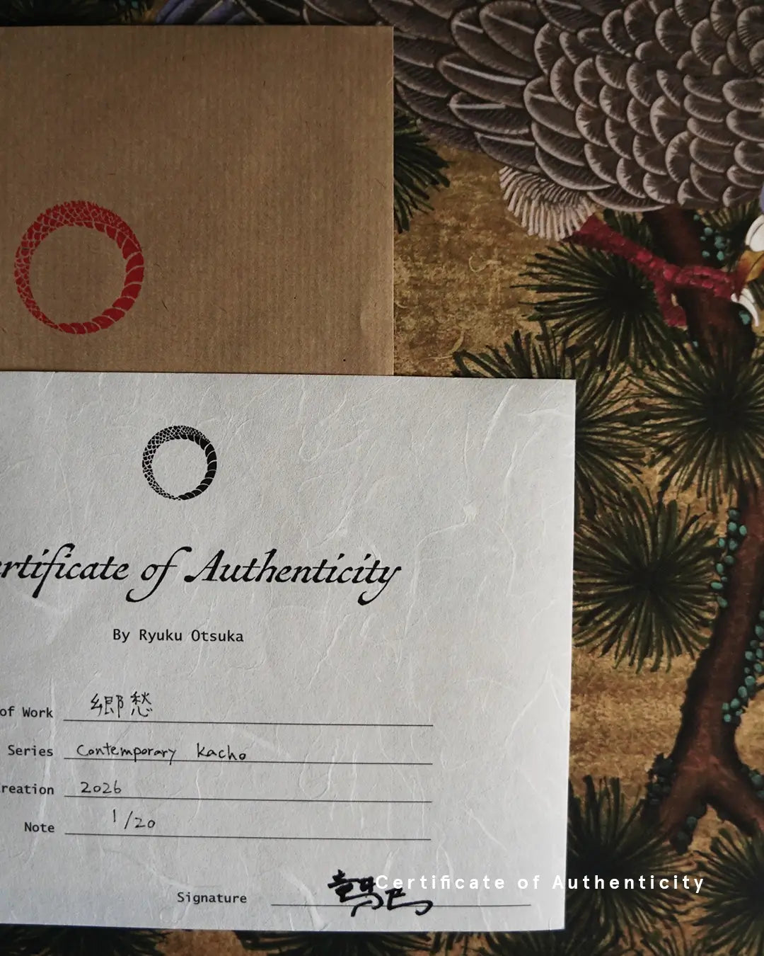 A close-up photograph of a Certificate of Authenticity printed on textured white washi paper for the fine art print "郷愁 - Nostalgia -" by Ryuku Otsuka. The document details the series "Contemporary kacho," creation year 2026, limited edition number "1/20," and artist signature, shown alongside a kraft envelope with a red circular stamp and wood pigeon feather artwork in the background.
