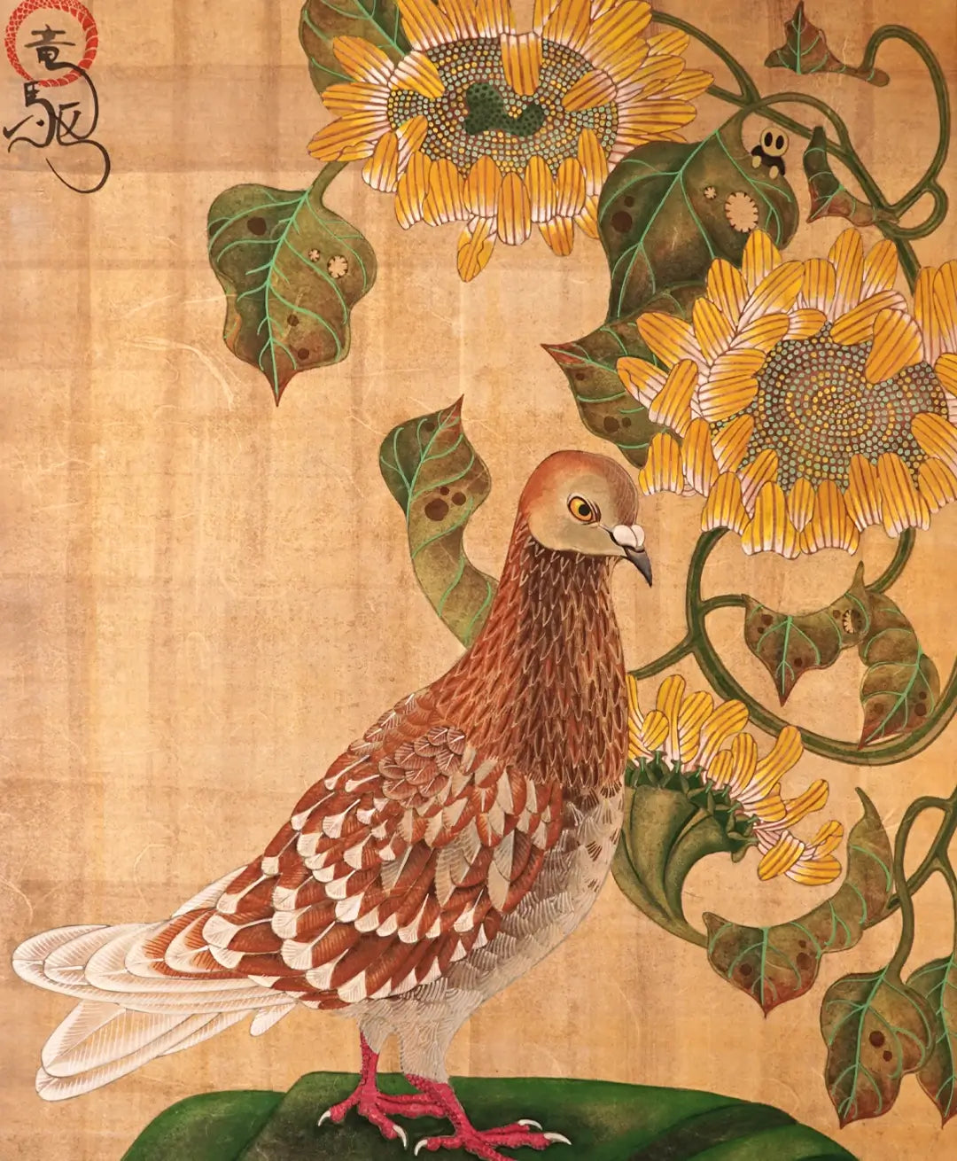A detailed close-up of the traditional Nihonga painting "固定概念 - Discourse -" by Ryuku Otsuka. The artwork features a reddish-brown and white patterned pigeon standing in profile over a soft green base, framed by vibrant, intricate yellow sunflowers on curling stems. Set against a warm, aged golden background texture on paper with an artist signature seal in the top left corner.